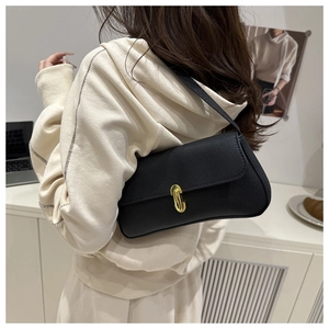 Close-up of black lychee grain leather underarm bag with elegant gold metal buckle clasp