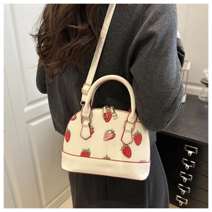 Detail shot of the white strawberry print pillow bag showing the adjustable shoulder strap