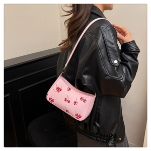 Detail of pink PU leather shoulder bag featuring red cherry print and golden hardware
