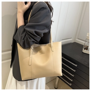 Detail of beige tote bag featuring Fashion & Bags logo and fine leather texture