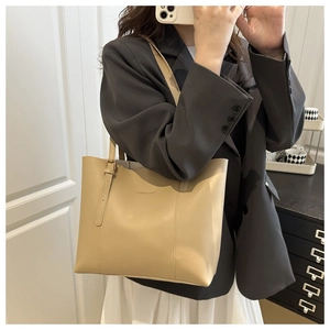 Detail shot of khaki tote bag with fashion lettering and high-quality leather texture