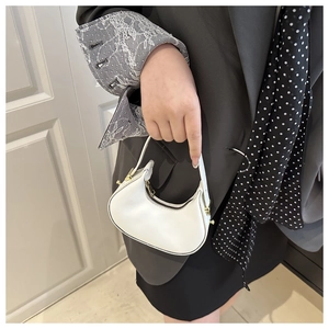 Close-up of a white leather mini hobo bag with gold zipper and elegant lace sleeve detail