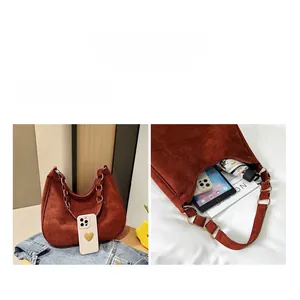 Close-up of brown suede hobo bag with gold ring and view of spacious interior storage