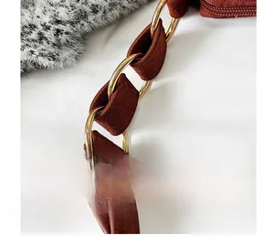 Detail of a brown frosted leather shoulder strap with gold metal rings and stitching