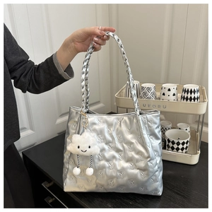 Detail of silver tote bag with quilted bear pattern and plush cloud charm accessory