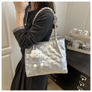 Detail of silver quilted tote bag with bear texture and cute plush cloud pendant charm