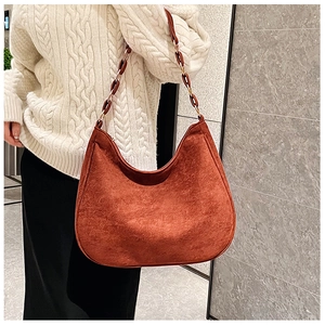 Caramel matte suede shoulder bag featuring amber resin and metal chain detail on model