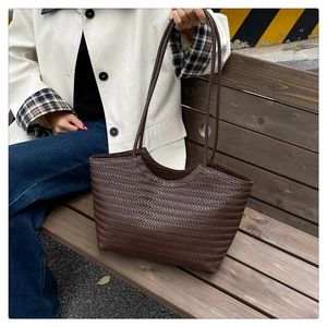 Dettaglio della trama intrecciata marrone scuro e dei lunghi manici di questa borsa retro