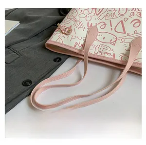 Dettaglio dei manici in pelle rosa e stampa graffiti sulla borsa tote beige
