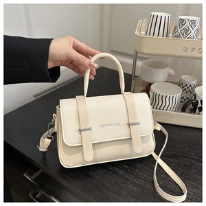 Détail du mini sac messager blanc crème avec boucles argentées et poignée