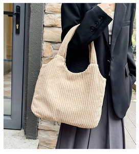 Detalle del bolso tote de pana beige con textura acanalada y gran capacidad en modelo