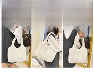 Detalle del bolso tote de pana blanco crema con textura acanalada y diseño amplio