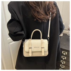 Détail d'un sac à bandoulière en cuir PU crème avec rabat grainé et bandoulière longue