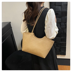 Dettaglio della trama intrecciata e dei manici di una borsa hobo vintage marrone