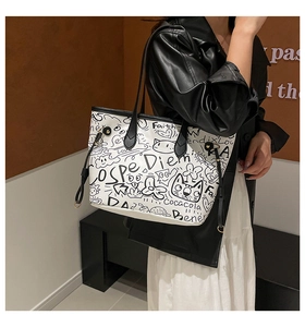 Dettaglio della grande borsa tote con graffiti indossata da una modella in stile street
