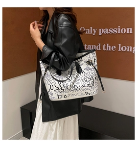Dettaglio della borsa tote bianca grande con stampe graffiti nere e manici in pelle
