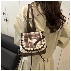 Detail of checkered flap backpack with star pattern and cherry label on the back of model