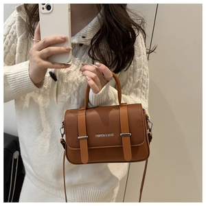 Détails du sac marron texture litchi avec boucle en métal argenté et bandoulière