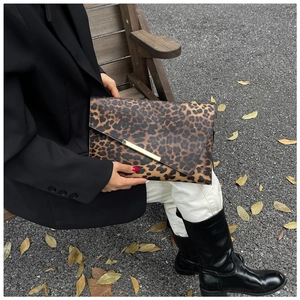 Close-up of leopard print envelope bag with elegant gold metal decorative clasp on flap