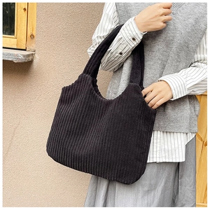 Primer plano del bolso tote de pana negra mostrando el tejido de pana y su textura suave