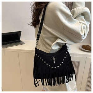 Detail of black suede bag with gothic silver studs, cross emblem and long flowing tassels