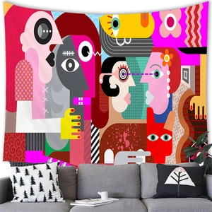 Detailed view of abstract face tapestry hanging above a sofa in a modern room