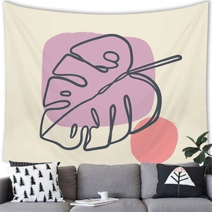 Close-up of minimalist monstera leaf tapestry with pink and coral shapes over a sofa