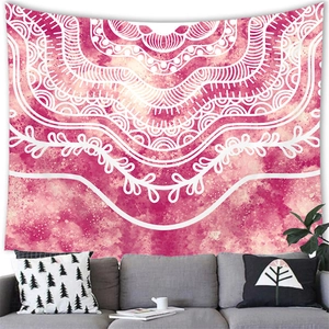 Detail of bohemian mandala tapestry featuring pink watercolor design on home wall