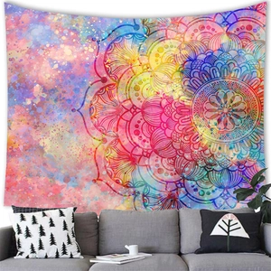 Detail of vibrant watercolor mandala tapestry hanging over a grey sofa in a modern room
