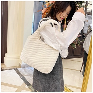 Detalle de la textura de pana vertical en este bolso de mano blanco de estilo minimal