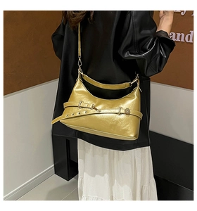 Detail of metallic gold crescent bag showing adjustable buckle and glossy texture
