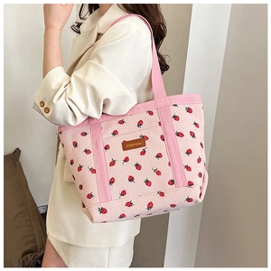 Close-up of strawberry print corduroy tote bag showing fabric texture and leather patch