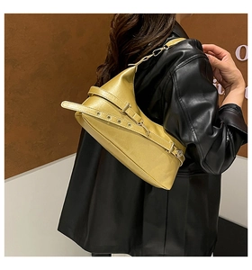 Detail of mustard yellow retro hobo bag with adjustable buckle strap on model