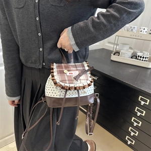 Mini backpack for women with brown plaid flap and star printed canvas in a lifestyle setting