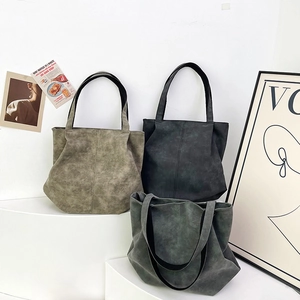 Three minimalist faux leather tote bags in vintage gray and green on studio pedestals