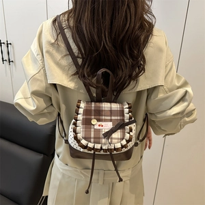 Chic plaid pattern backpack with ruffle trim and cherry tag on a female model