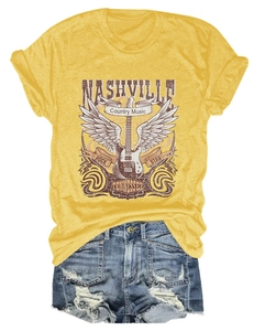 Flat lay of yellow Nashville T-shirt with vintage guitar graphic and distressed denim shorts