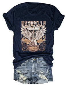 Flat lay of Nashville country music t-shirt with distressed denim shorts and guitar print