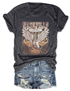 Flat lay of Nashville rock star graphic tee with distressed denim shorts on white background