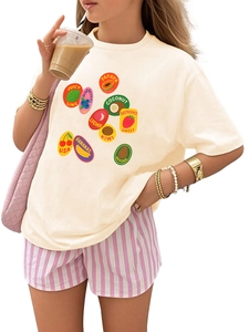 Détail d'un t-shirt crème avec motifs de fruits colorés et imprimé cerise avec texte USA