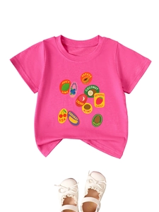 Détail de l'imprimé fruits sur t-shirt rose avec élégantes chaussures Mary Jane blanches