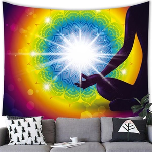 Mandala tapestry with yoga meditation silhouette above a grey sofa in a modern room