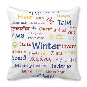 Détail d'une housse de coussin blanche avec typographie d'hiver en plusieurs langues