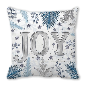 Dettaglio del cuscino natalizio con scritta JOY argentata e aghi di pino blu decorativi