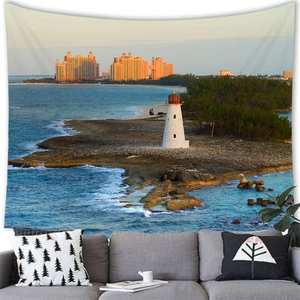 Watercolor nautical tapestry featuring lighthouse and tropical resort over a grey sofa