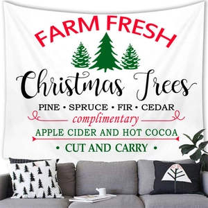 Detail of a Christmas tree tapestry hanging over a sofa in a warm festive living room