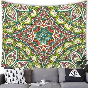 Détail d'une tapisserie mandala bohème suspendue au-dessus d'un canapé gris aux motifs vifs