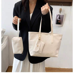 Detailed close-up of a three-piece beige tote bag set with textured synthetic leather