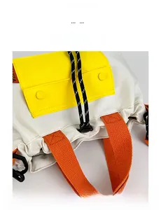 Detail view of nylon crossbody bag featuring contrast yellow pocket and orange handle