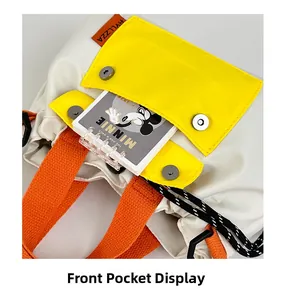 Detail view of the nylon crossbody bag showing the yellow front pocket and magnetic buckles